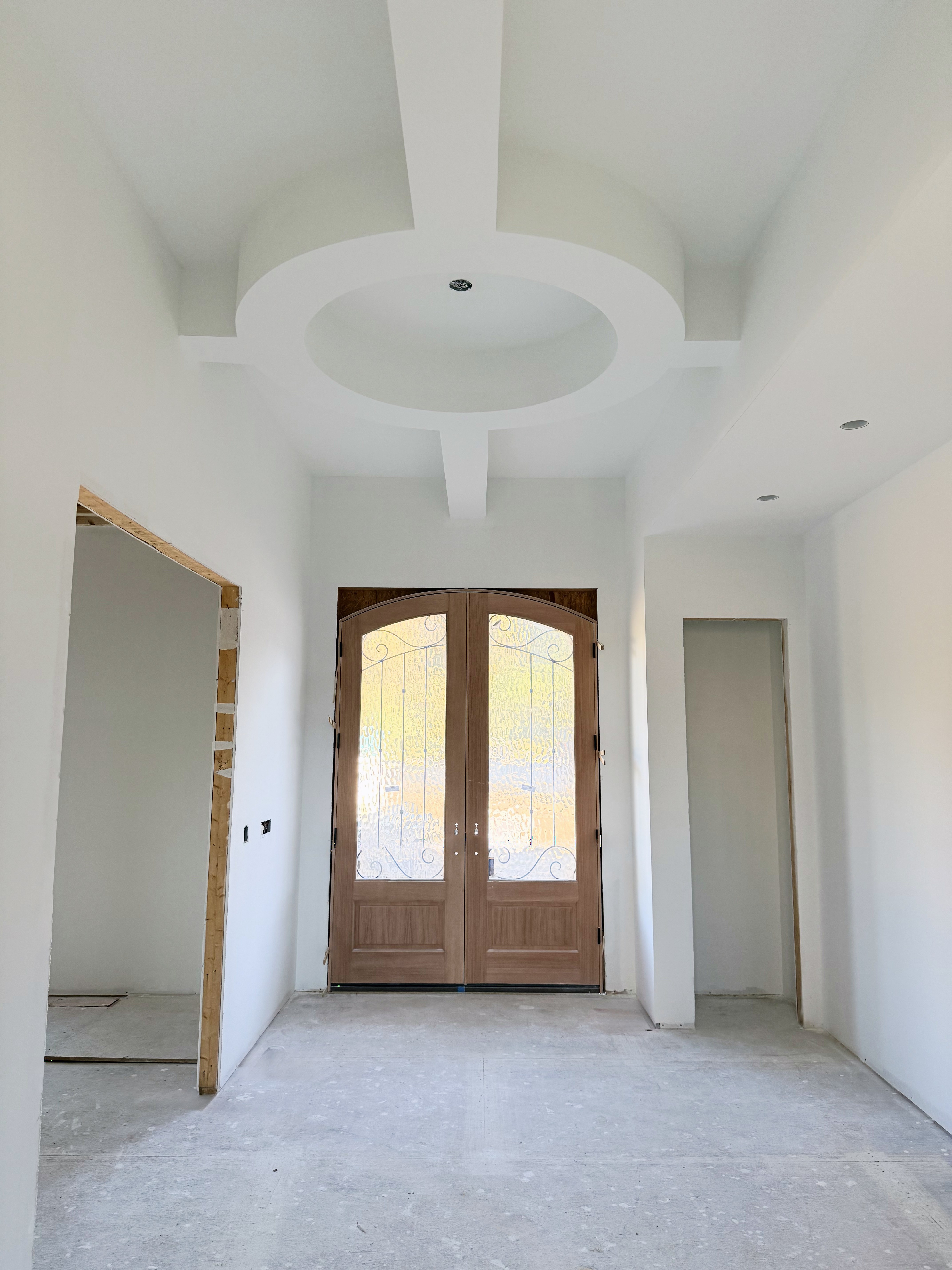 New build: entry foyer with a round tray ceiling and arched double front doors